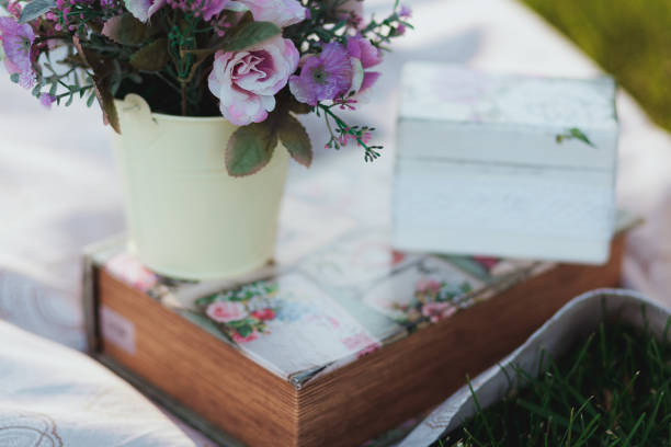 istock Beautiful artificial flower on white tablecloth with grass on background 843976076