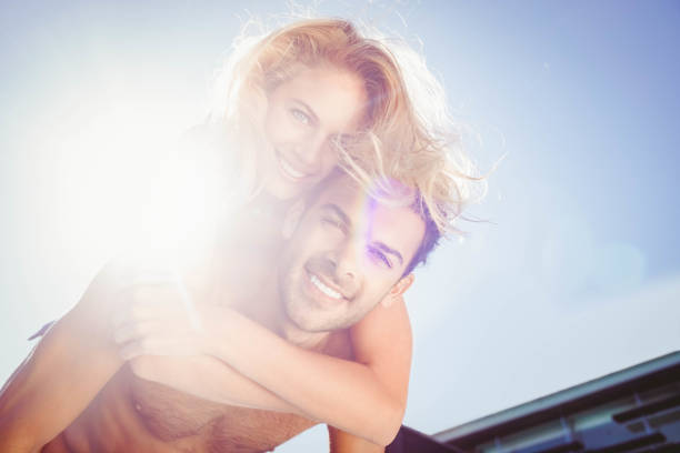 Boyfriend giving piggy back to his girlfriend by the pool