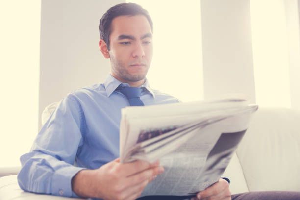 istock Handsome businessman reading newspaper 843976530