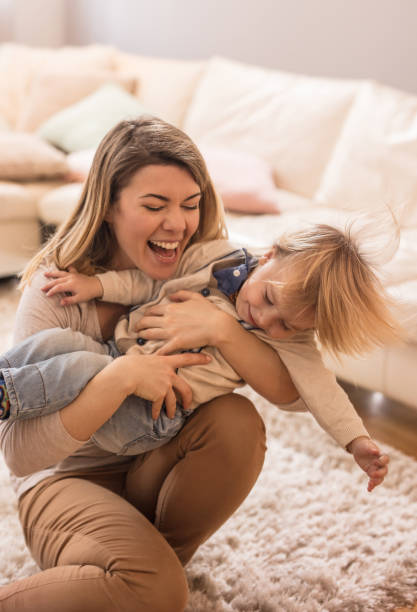 istock Joyful mother playing with her small boy at home. 843978228
