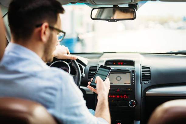 istock Businessman ignoring safety and texting onmobile phone while driving 843989846