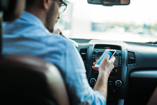 istock Businessman ignoring safety and texting onmobile phone while driving 843989882