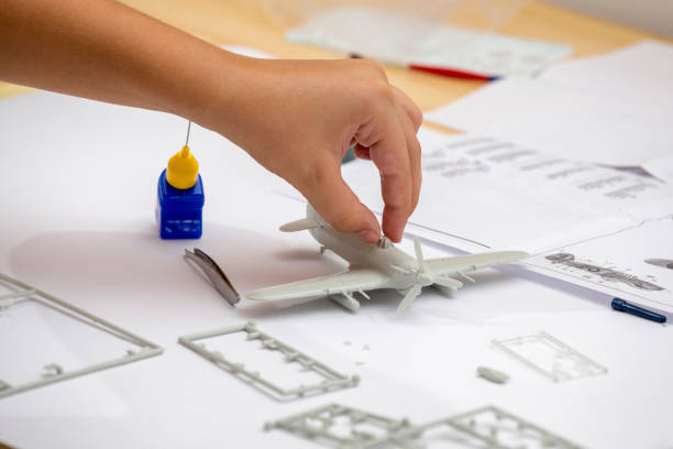 istock Boy hand assembling plastic model kit of ww2 aircraft 843990410