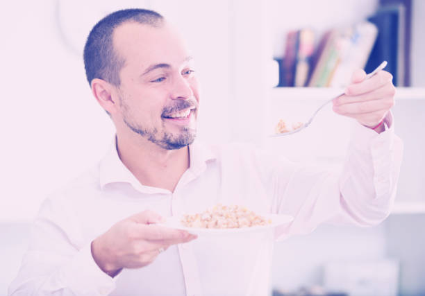 istock Positive young man eating porridge 844000070