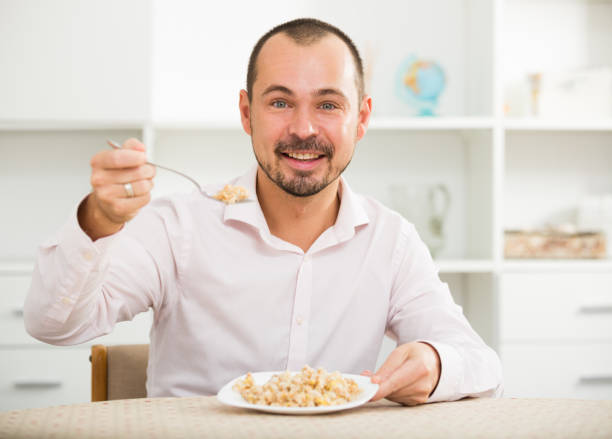 istock Positive young man eating porridge 844000108