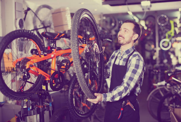 istock Worker man sets the wheel on the bike 844004696