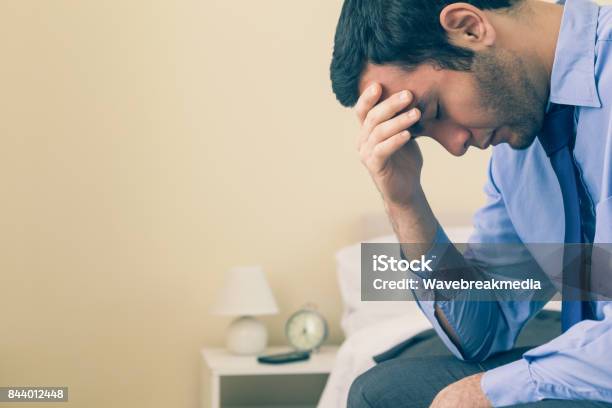 Sad Man Sitting Head In Hands On His Bed Stock Photo - Download Image Now - 20-24 Years, 20-29 Years, Adult
