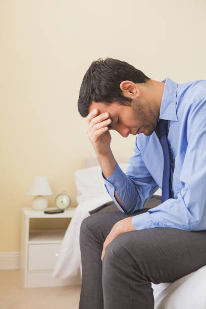 istock Upset man sitting head in hands on his bed 844012704