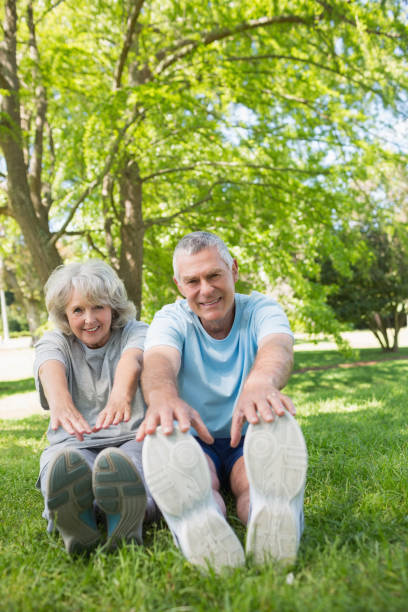 istock Mature couple stretching hands to legs at park 844012794