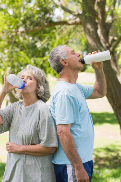 istock Mature couple drinking water at park 844013184