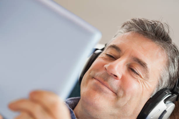 istock Smiling man listening music and using a tablet pc 844015588