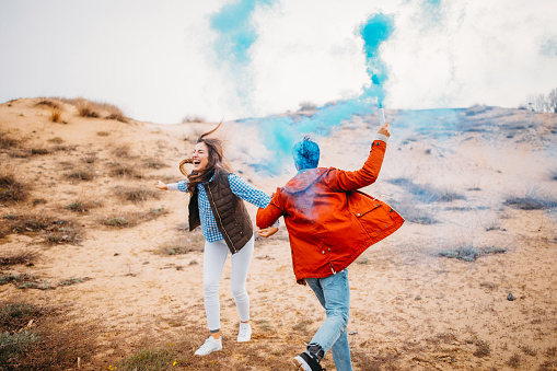Man dancing with his girlfriend with a smoke bomb in hand.