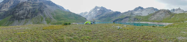 istock Young woman standing beside tent arms outstretched 844031446