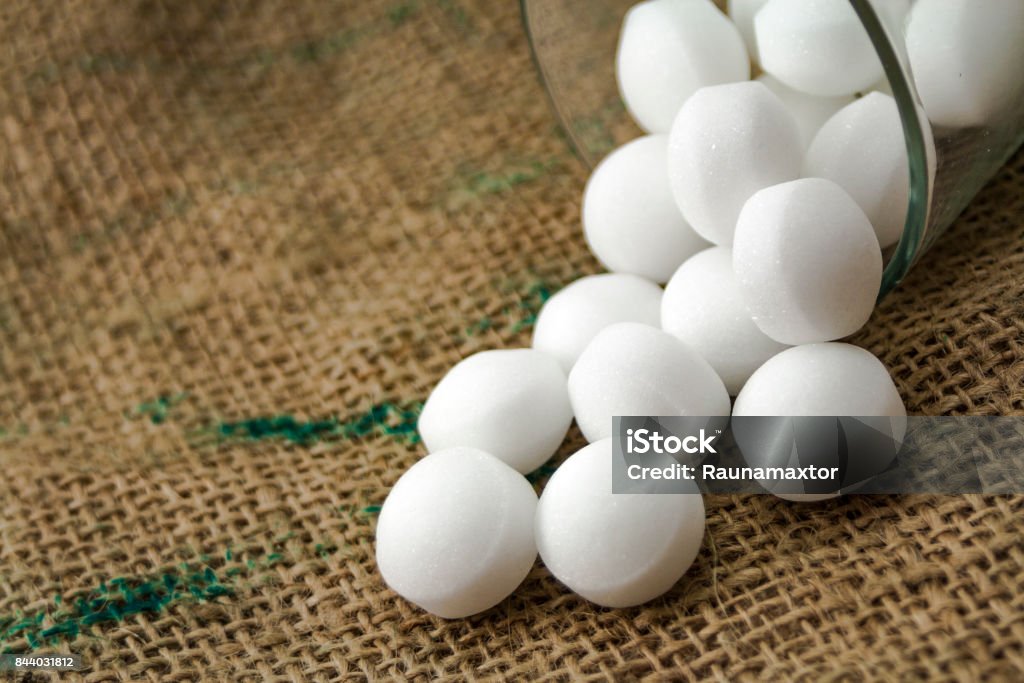 Moth balls in the glass over the sackcloth Moth balls in the glass over the sackcloth. Sphere Stock Photo