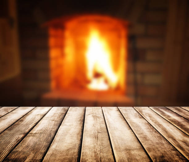 istock Old wooden table and blurred of fireplace 844036096