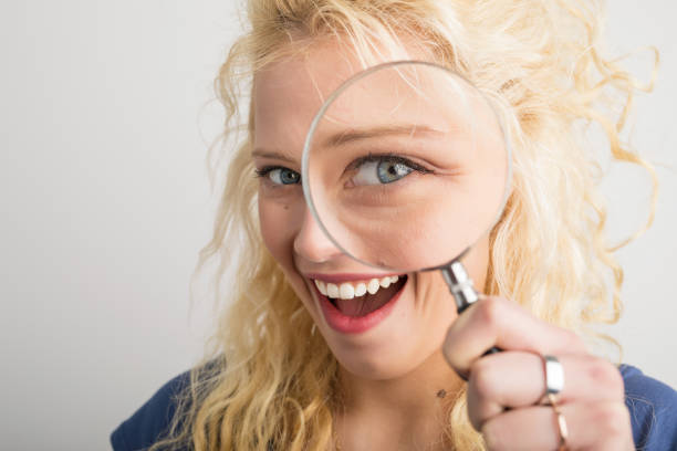 istock Woman looking through magnifying glass 844040978