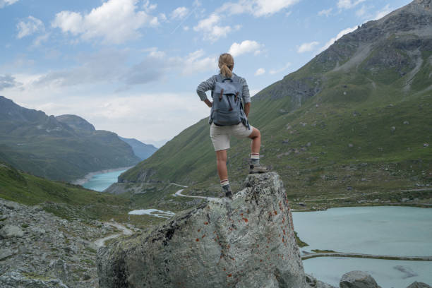 istock Hiker on top of rock looking at mountain lake 844045848