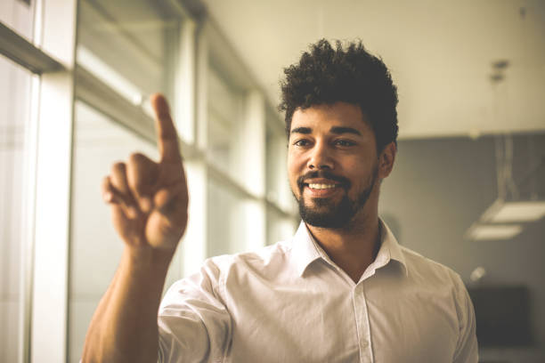 Close up.  African business man holding finger on touch screen.
