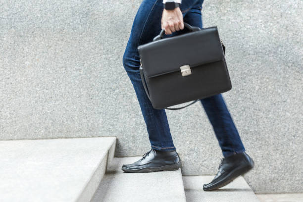 hombre de negocios con maletín en la mano subiendo escaleras. - men briefcase business bag fotografías e imágenes de stock