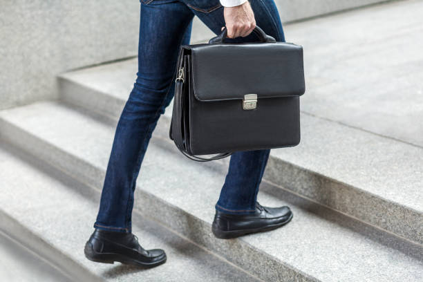 hombre de negocios con maletín en la mano subiendo escaleras. - men briefcase business bag fotografías e imágenes de stock