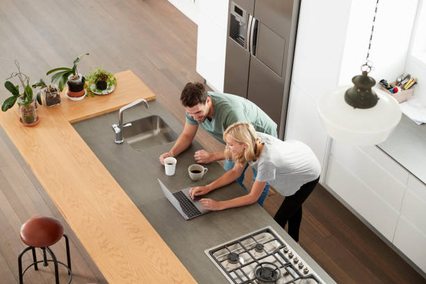 istock Overhead View Of Couple Looking At Laptop In Modern Kitchen 844050392