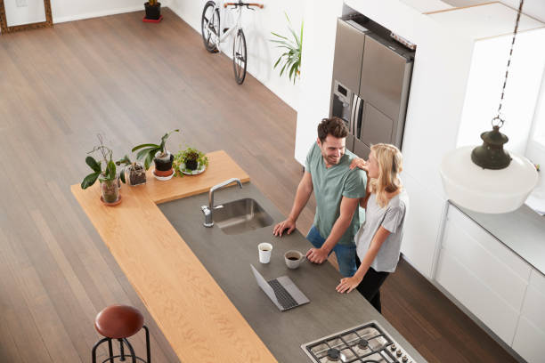 vista aérea de pareja mirando la laptop en la cocina - electrodoméstico fotos fotografías e imágenes de stock