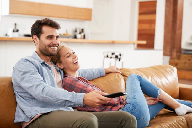 istock Couple Sitting On Sofa Watching Television Together 844053902
