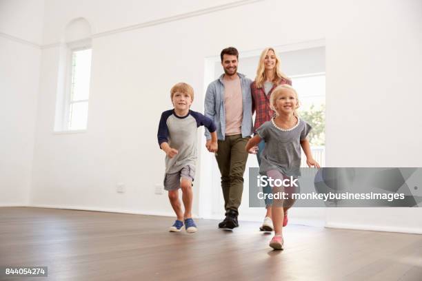 Excited Family Explore New Home On Moving Day Stock Photo - Download Image Now - Moving House, Family, Young Family