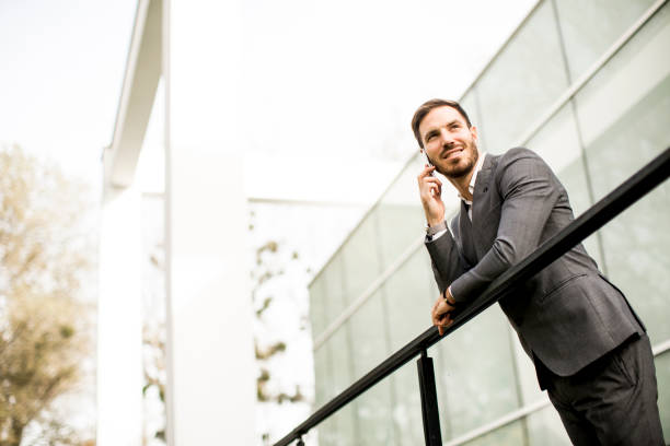 istock Handsome young businessman with mobile phone by the office building 844054834