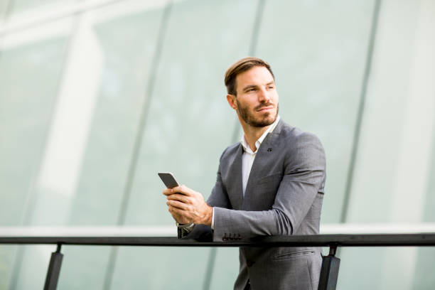 istock Handsome young businessman with mobile phone by the office building 844054856
