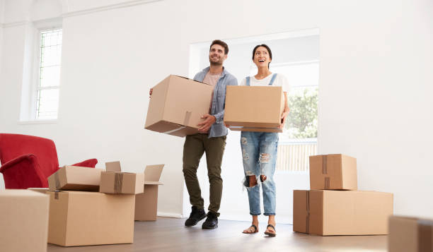 Couple Carrying Boxes Into New Home On Moving Day stock photo