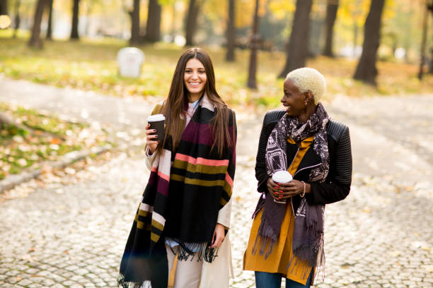istock Two young pretty multiracial girlfriends at autumn day 844057230
