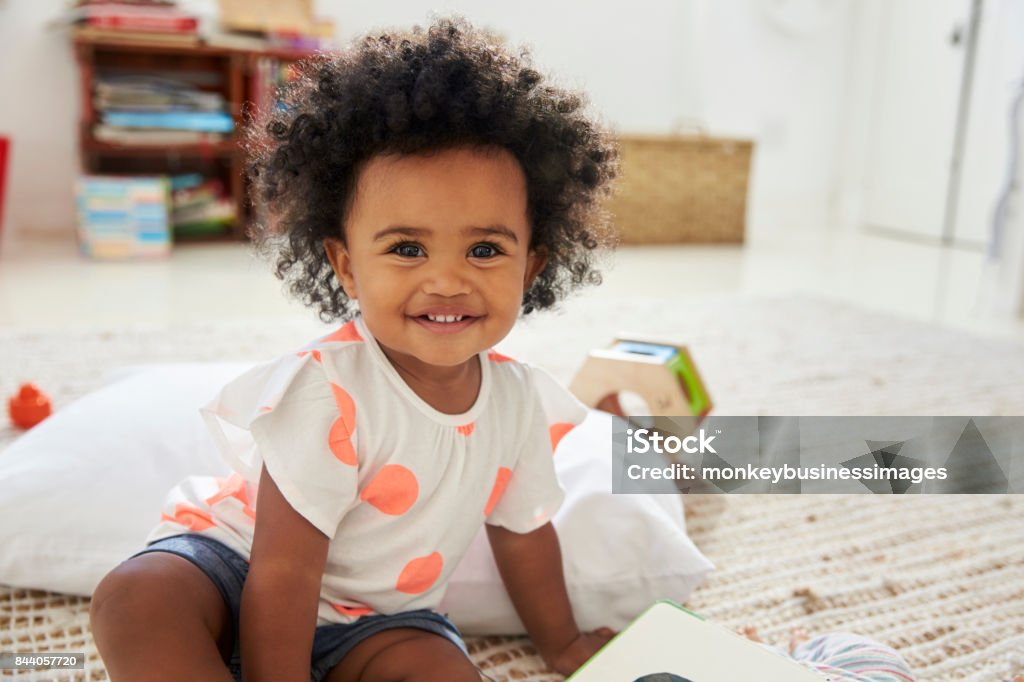 Portrait Of Happy Baby Girl Playing With Toys In Playroom Baby - Human Age Stock Photo