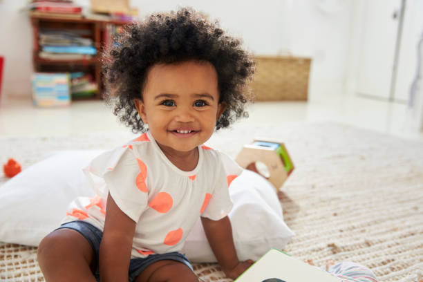 Portrait Of Happy Baby Girl Playing With Toys In Playroom Portrait Of Happy Baby Girl Playing With Toys In Playroom toddler stock pictures, royalty-free photos & images