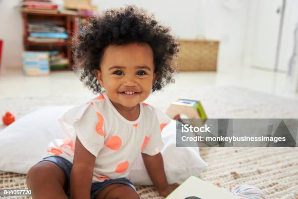 Portrait Of Happy Baby Girl Playing With Toys In Playroom Stock Photo - Download Image Now