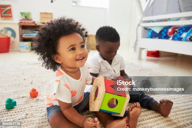 Baby Boy And Girl Playing With Toys In Playroom Together Stock Photo - Download Image Now