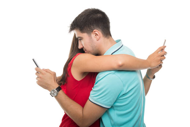 istock Couple embracing and texting on smartphones 844062308