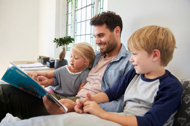 istock Father With Children Sitting On Bed Reading Book Together 844063824