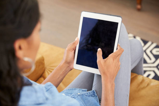 istock Woman Sitting On Sofa At Home Looking At Digital Tablet 844063858