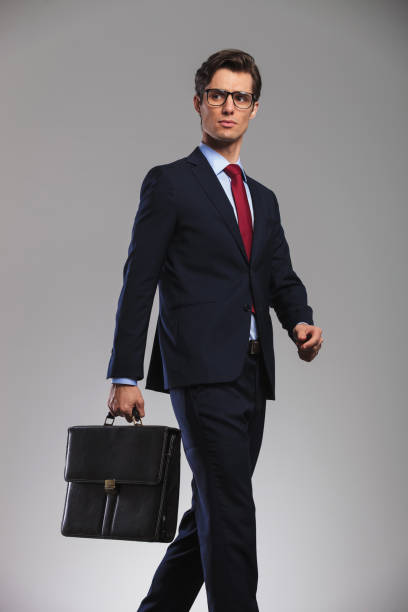 istock walking business man holding a suitcase and looks away 844063908