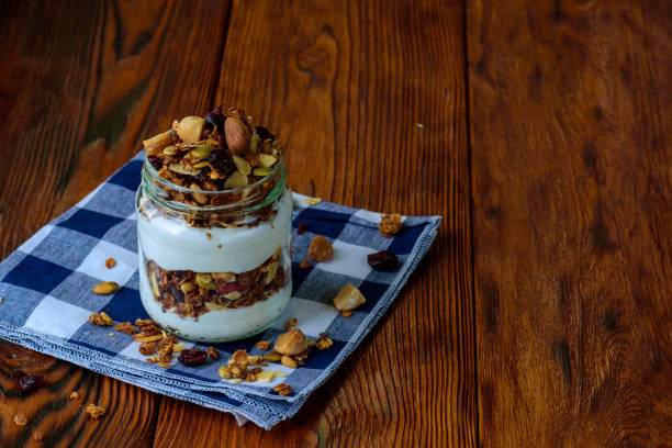 istock Granola with yogurt on wooden table. 844070664