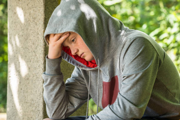 istock Unhappy Boy Sitting In Park 844070936