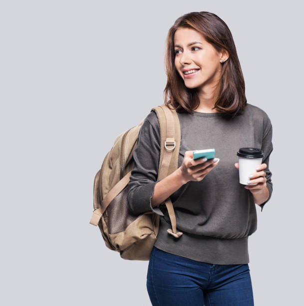 menina feliz jovem estudante usando telefone inteligente - tourist backpack smiling cheerful - fotografias e filmes do acervo