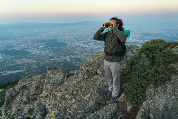 istock Man looking through binocular and enjoying the view from the mountaintop 844073912
