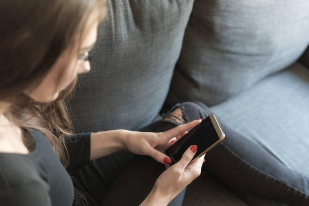 istock Young woman on smartphone, over the shoulder view 844078276