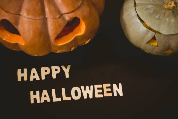 istock Happy Halloween text by jack o lanterns over black background 844080444