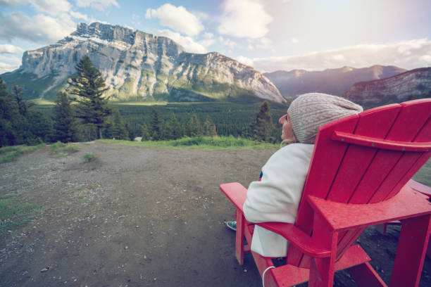 istock Young woman contemplating nature from deck chair, Canada 844088452