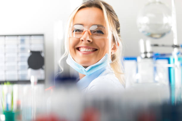 felice giovane attraente scienziato donna sorridente in laboratorio - research smiling scientist women foto e immagini stock