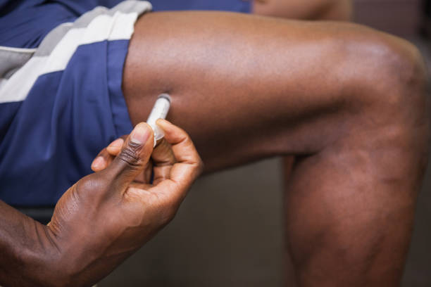 Muscular man injecting steroids Close up of muscular man injecting steroids in the gym hand thigh stock pictures, royalty-free photos & images