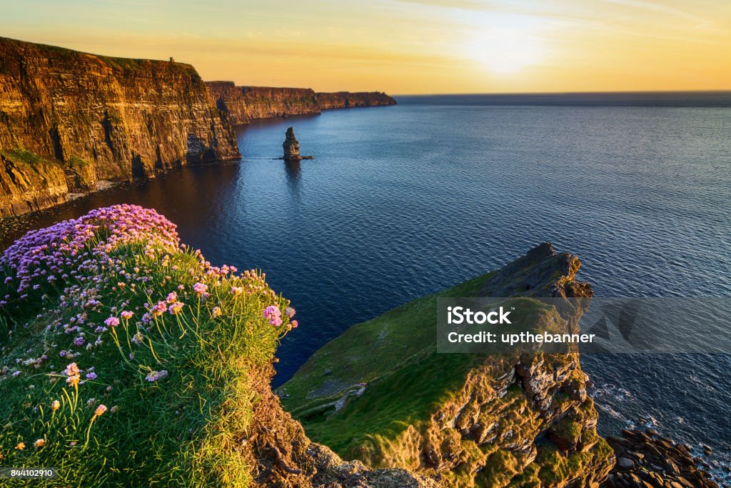 sunset at the cliffs of moher in county clare, ireland. beautiful evening scenic view from the wild atlantic way epic sunset at the cliffs of moher in county clare, ireland. beautiful evening scenic view from the wild atlantic way Ireland Stock Photo